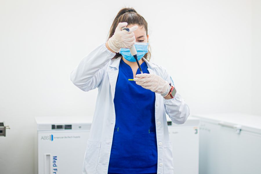 A laboratory professional using a pipette