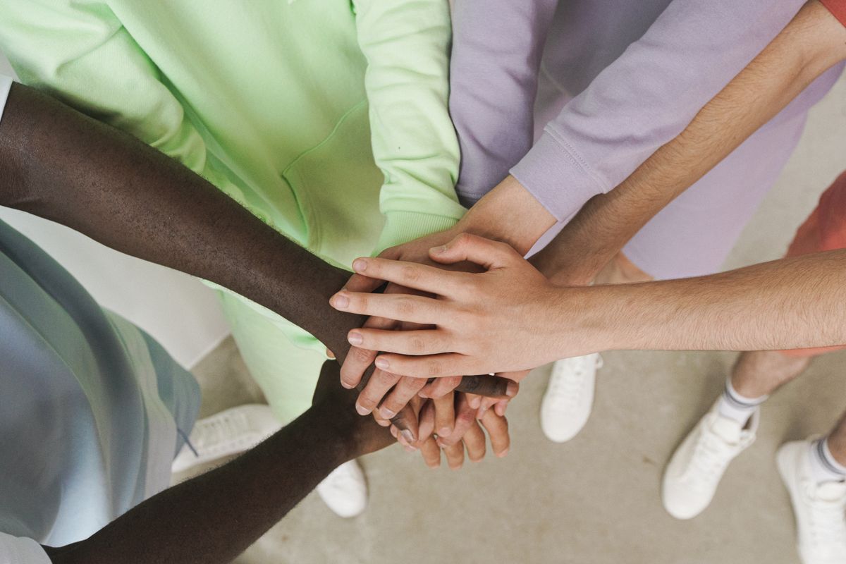 Several people placing their hands together in a circle