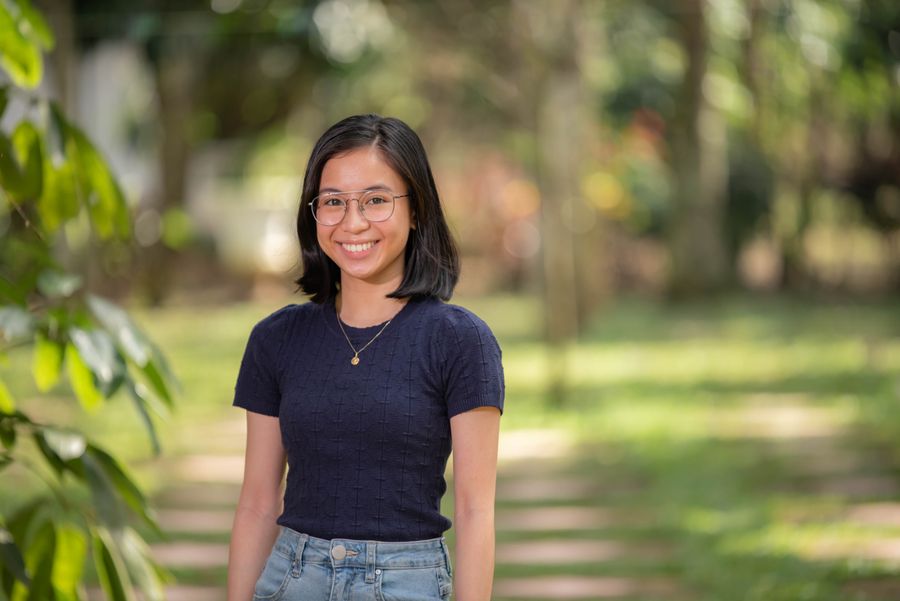 A smiling woman in a navy top standing in a park